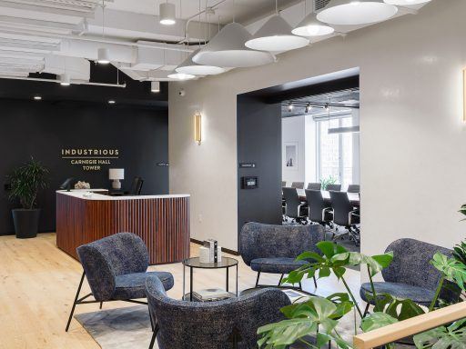 Oak wood flooring and ample greenery create an inviting reception area in Industrious Carnegie Hall Tower.