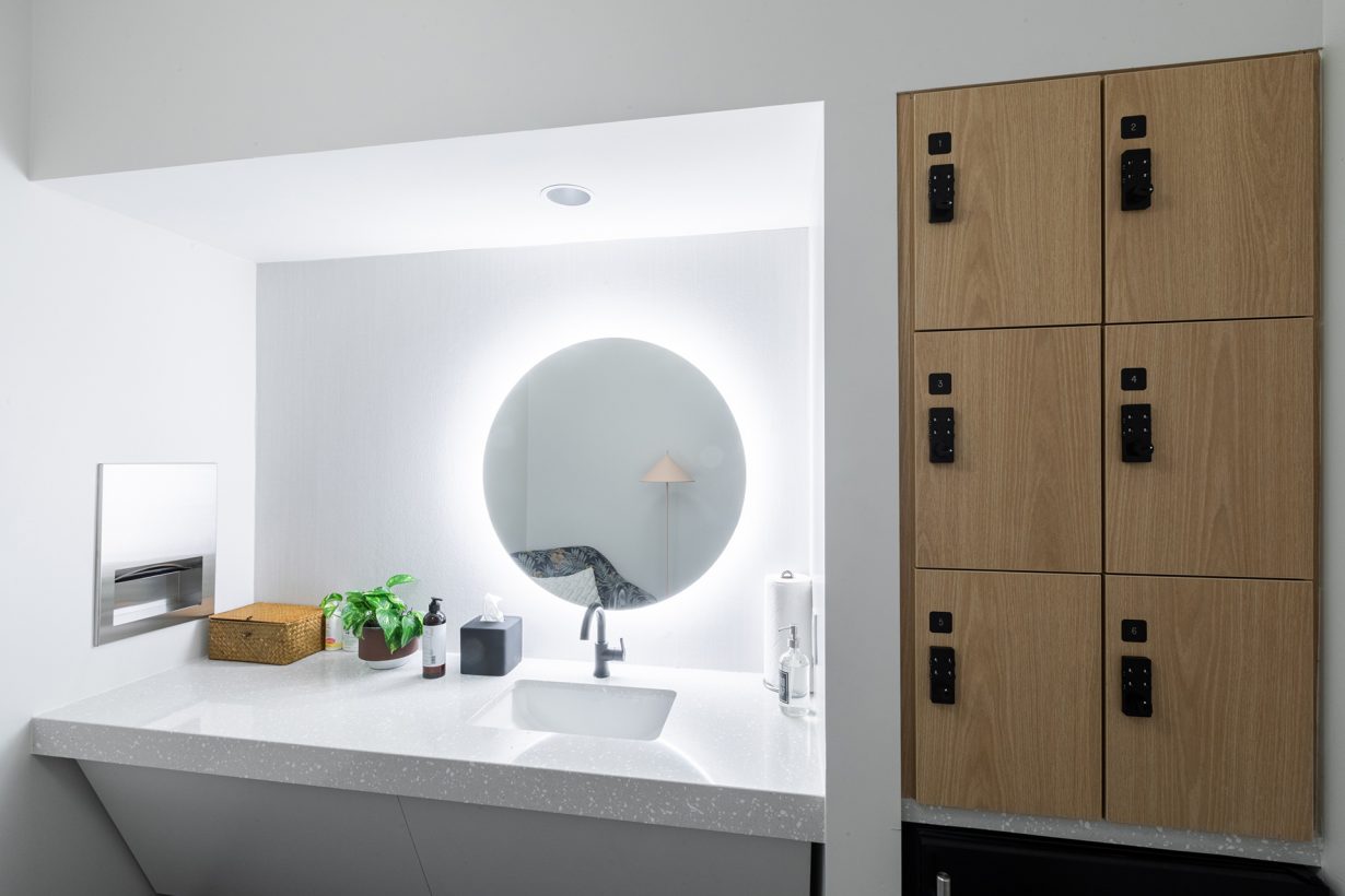 The wellness room includes a comfortable chair, sink area, and locker space.