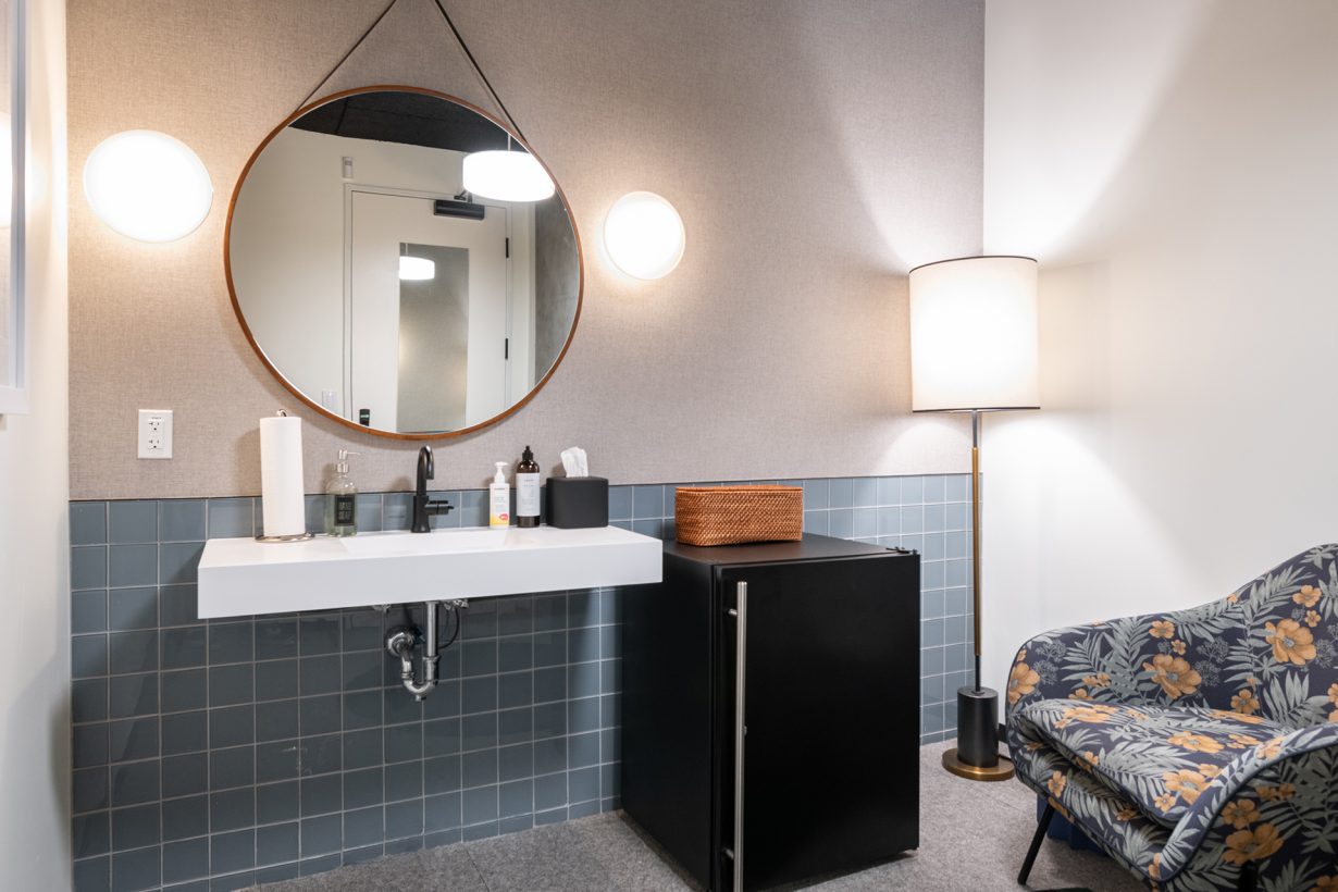 This wellness room contains a comfortable chair, mini fridge, and sink, and can be locked for privacy.